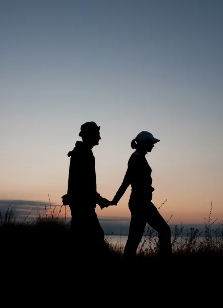 Young couple silhouettes at sunrise time