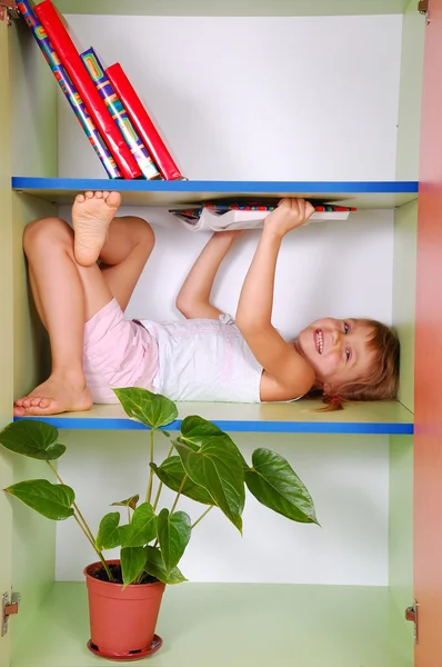 Child reading a book in a bookcase