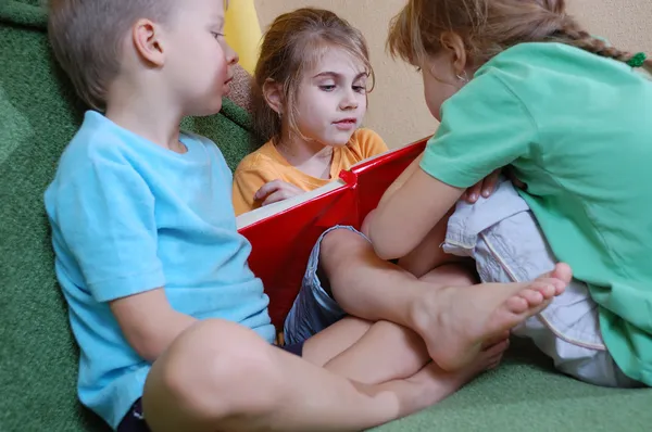 Three kids reading at home