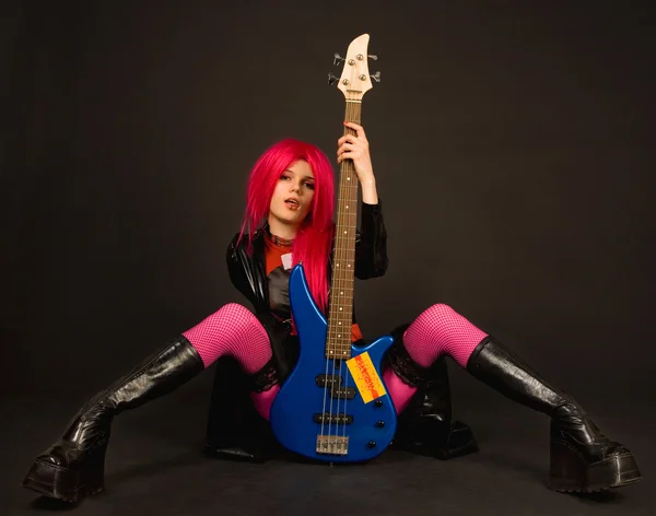 Attractive rock girl sitting with bass g