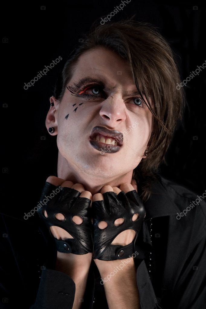 Expressive gothic boy with artistic makeup and blue lenses 