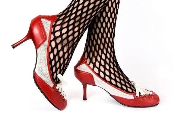 Female legs in red shoes