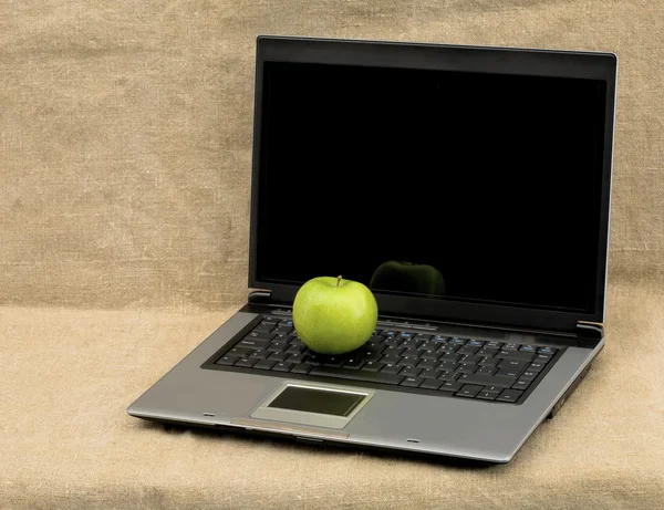 Laptop and green apple