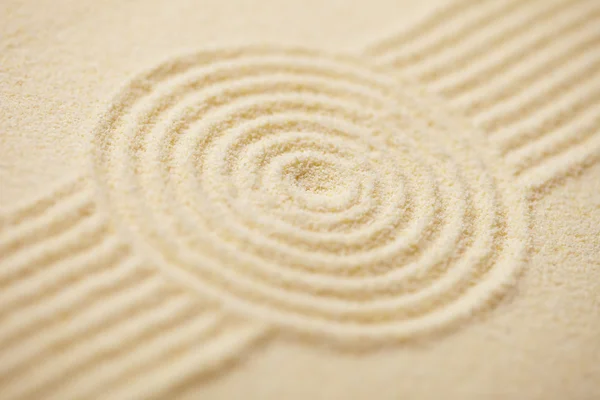Circle drawn on sand of rock-garden