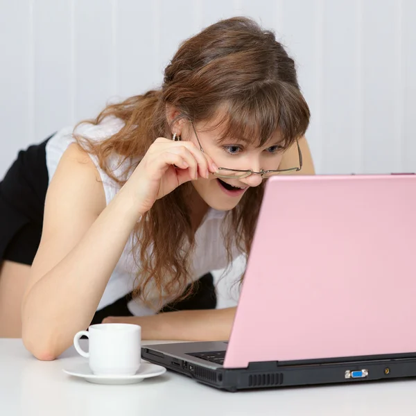 Young woman working with pink laptop