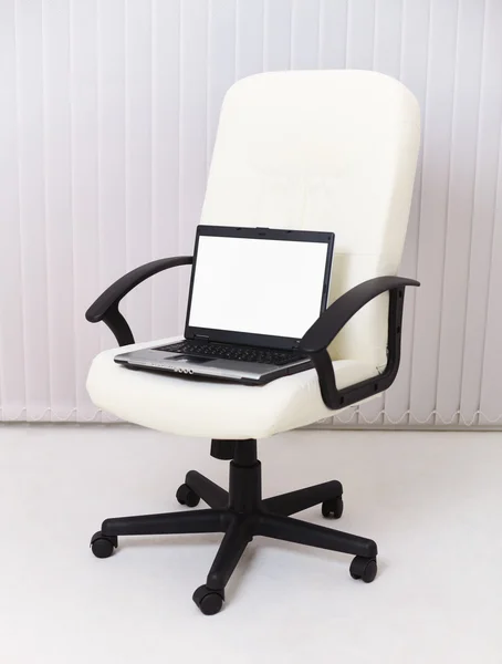 Laptop sits in leather chair for manager
