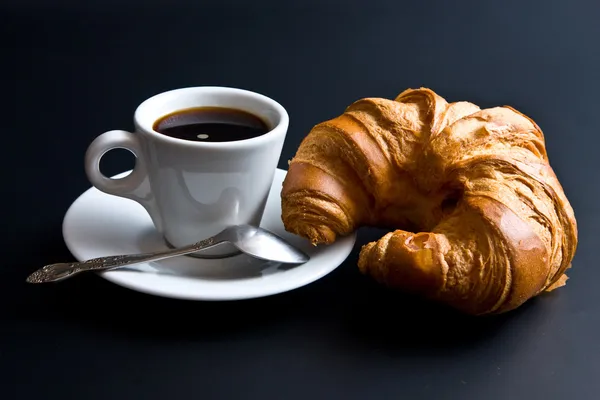 White cup coffee, spoon and croissant