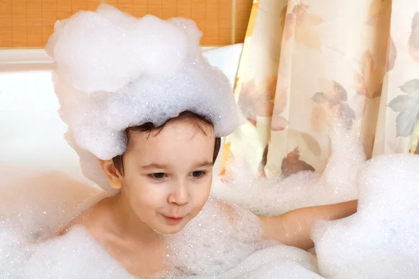 Little boy sits in a bath
