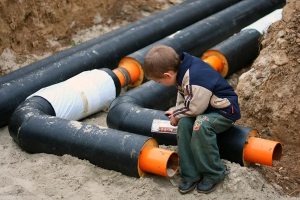 Child sitting on a pipe