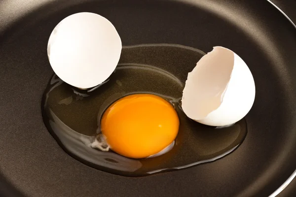 Broken egg on black pan