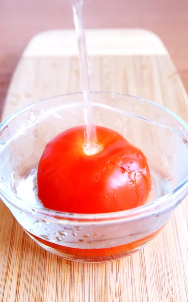 Steaming fresh tomato with hot water