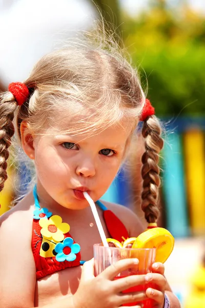 Child girl in red bikini drink juice