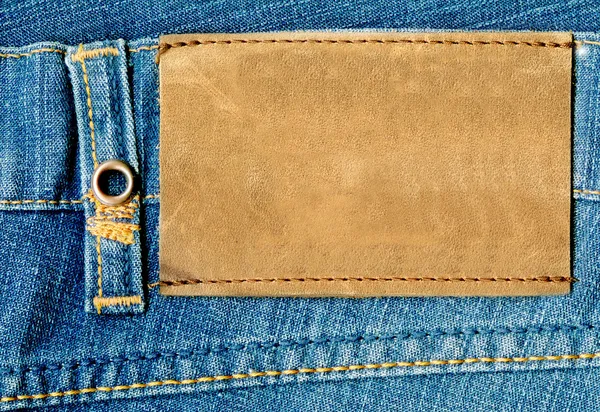 Blank leather label on blue jeans.