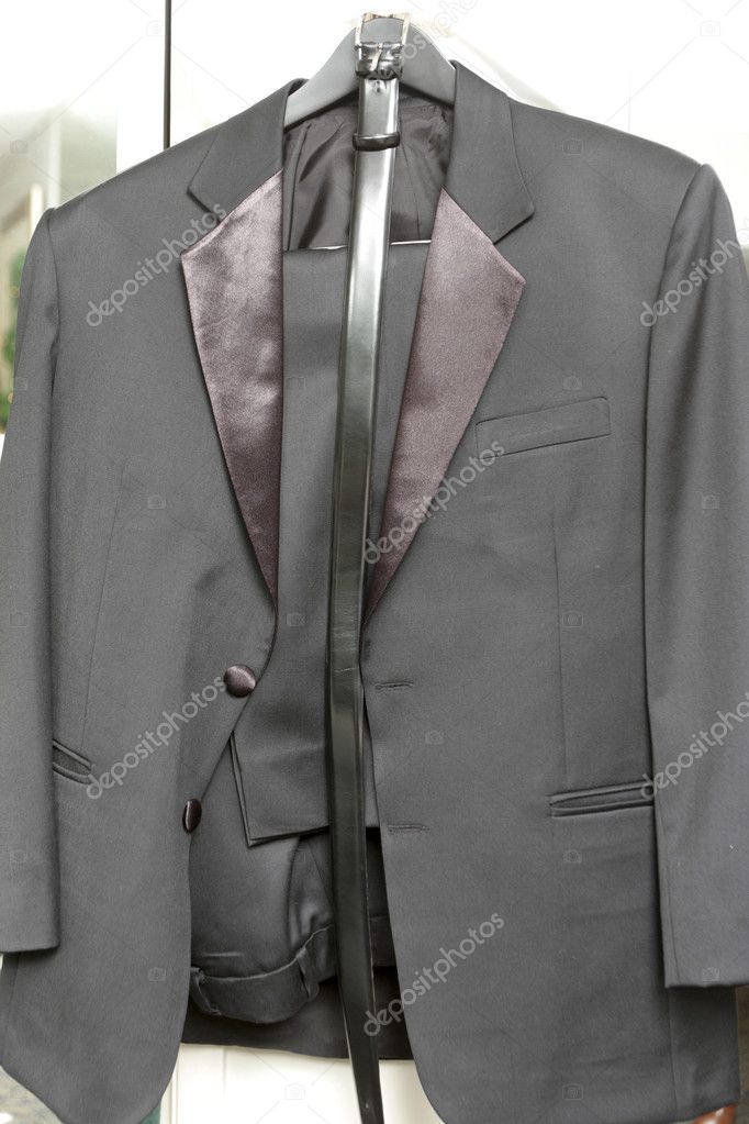 The wedding tuxedo with a belt on a hanger