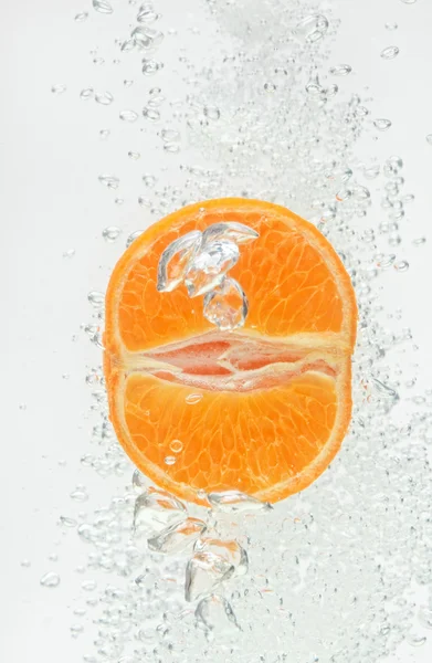 Orange (mandarin) falling in clear water