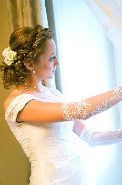 Bride in a wedding dress against window by Viktoriya Kirillova Stock Photo