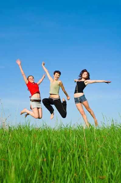 Girls jump on the meadow