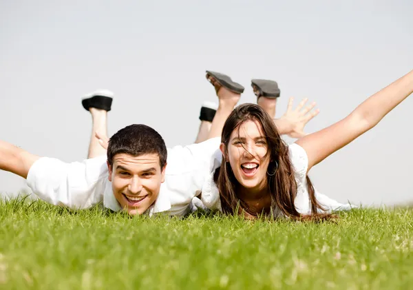 Cute young Couple lie down on grass — Stock Photo #1142550
