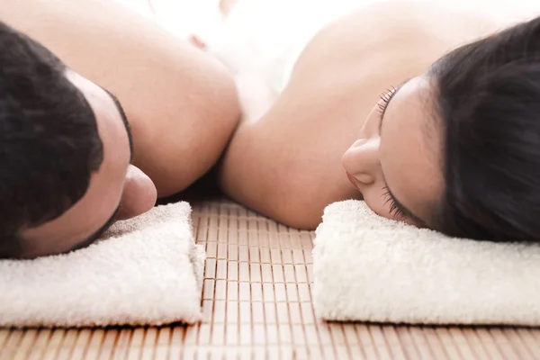 Man and woman lying on towel for spa