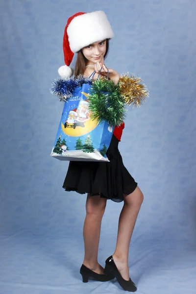 Girl with purchases in the Christmas cap