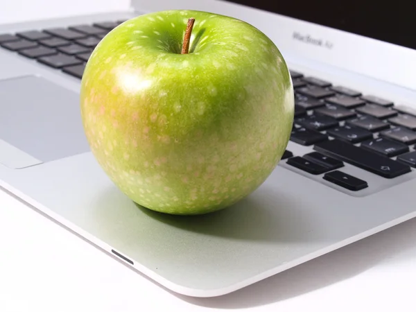 The laptop and green apple
