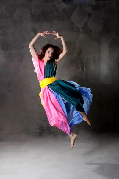 Young modern dancing girl in colorful dress