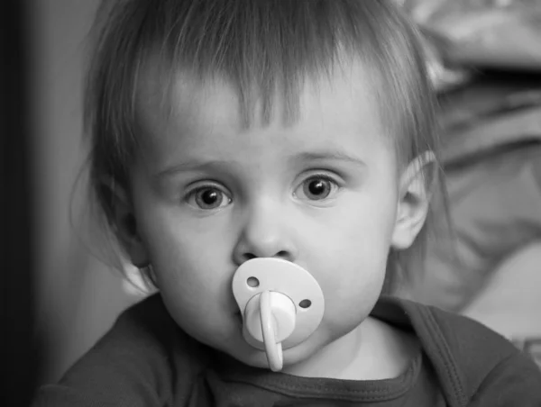 Baby with pacifier, black and white