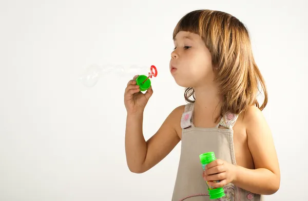 Cute girl blowing soap bubbles