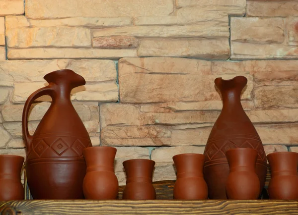 Clay jugs and cups on a shelf