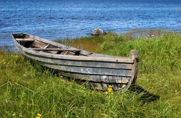 Old wooden boat on the lake bank
