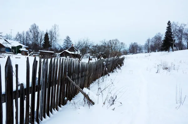 Snowy footpath near wooden fence