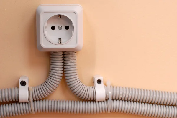 Electric socket on cream wall