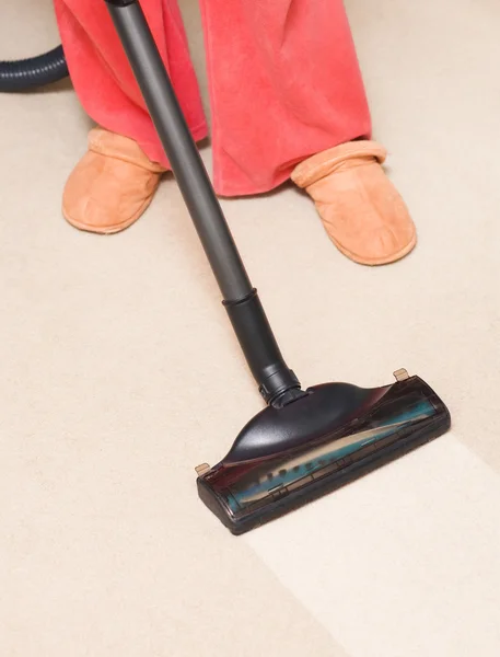 Housewife vacuum a carpet