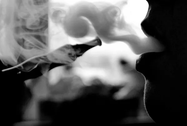 The woman smokes a hookah a close up