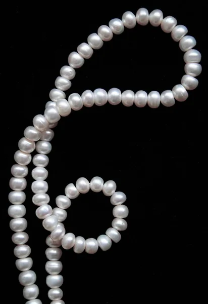 white pearls on the black silk as backgr