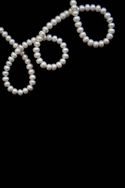 White pearls on the black silk