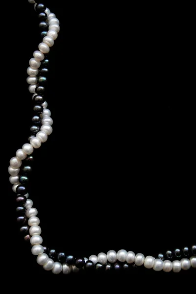 White and black pearls on a black