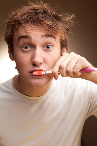 Young man cleans teeth