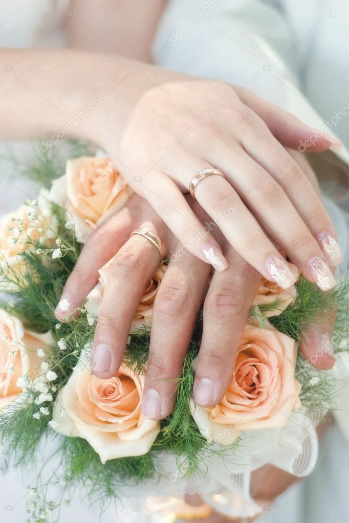 Wedding bouquet from pastel pink roses hands and rings