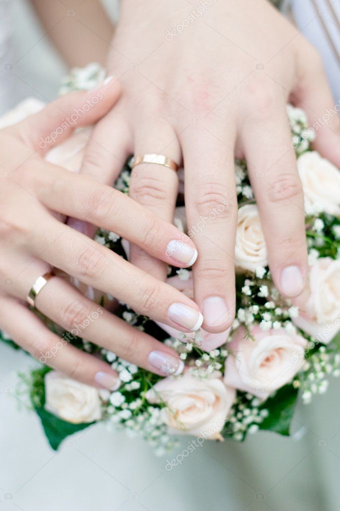 Wedding bouquet from pastel pink roses hands and rings