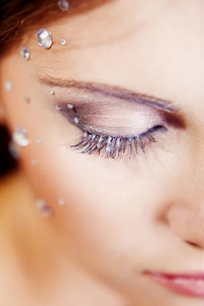 Half face with eye make-up and sparkles