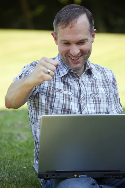 Happy man with laptop outdoor