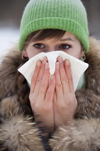 Woman sneezing in handkerchief