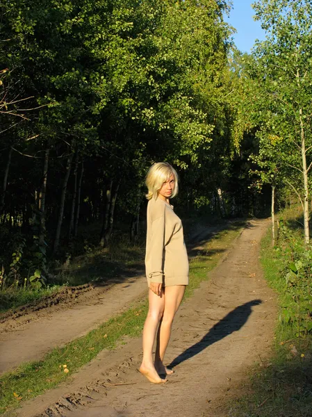 Girl walking away along the forest road