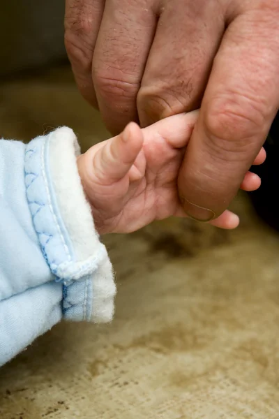 Small child keeping finger of father