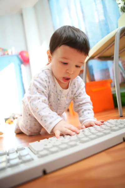 Baby and computer keyboard, soft focus — Stock Photo #1383160