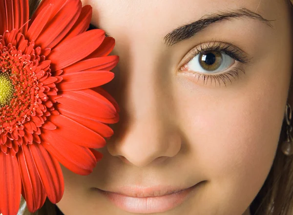 Close-up woman eyes and gerbera flower