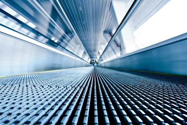 Close-up of moving escalator in blue