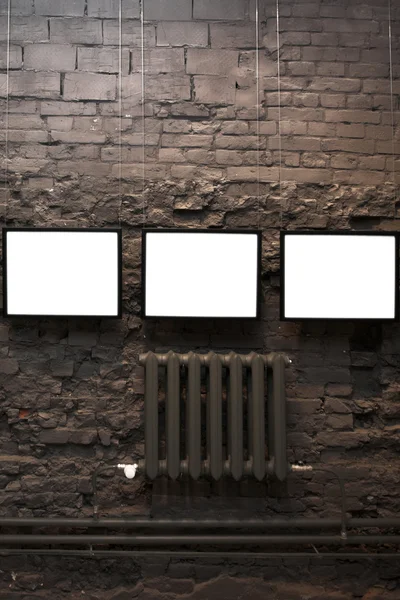 Four empty frames on brick wall
