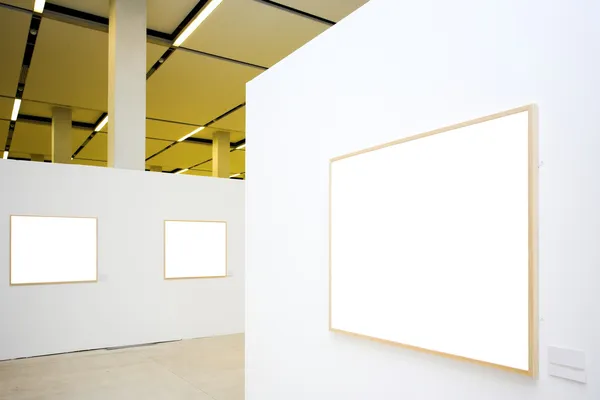 Three empty frames on white wall